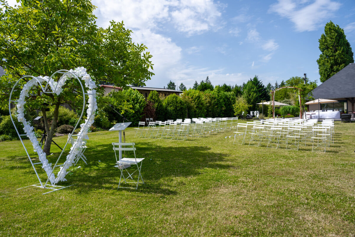 Cérémonie en extérieur, arche fleurie et chaises de réception